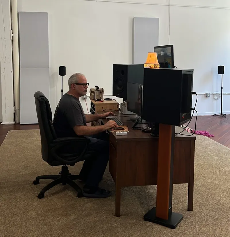 daniel-baruch-sitting-in-front-of-his-computer-studio